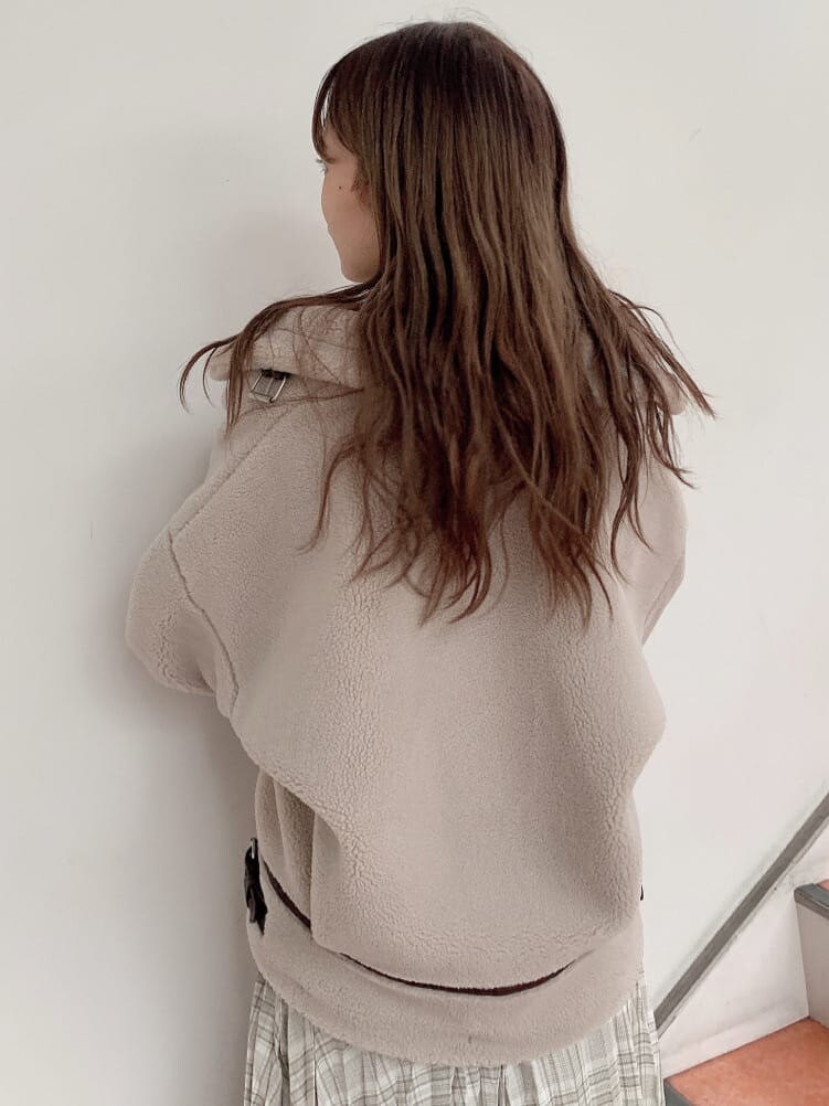 グリーン系のスカート、ホワイト系のニット/セーター、ベージュ系のブルゾンを着用したレディースの秋コーディネートの4枚目の写真