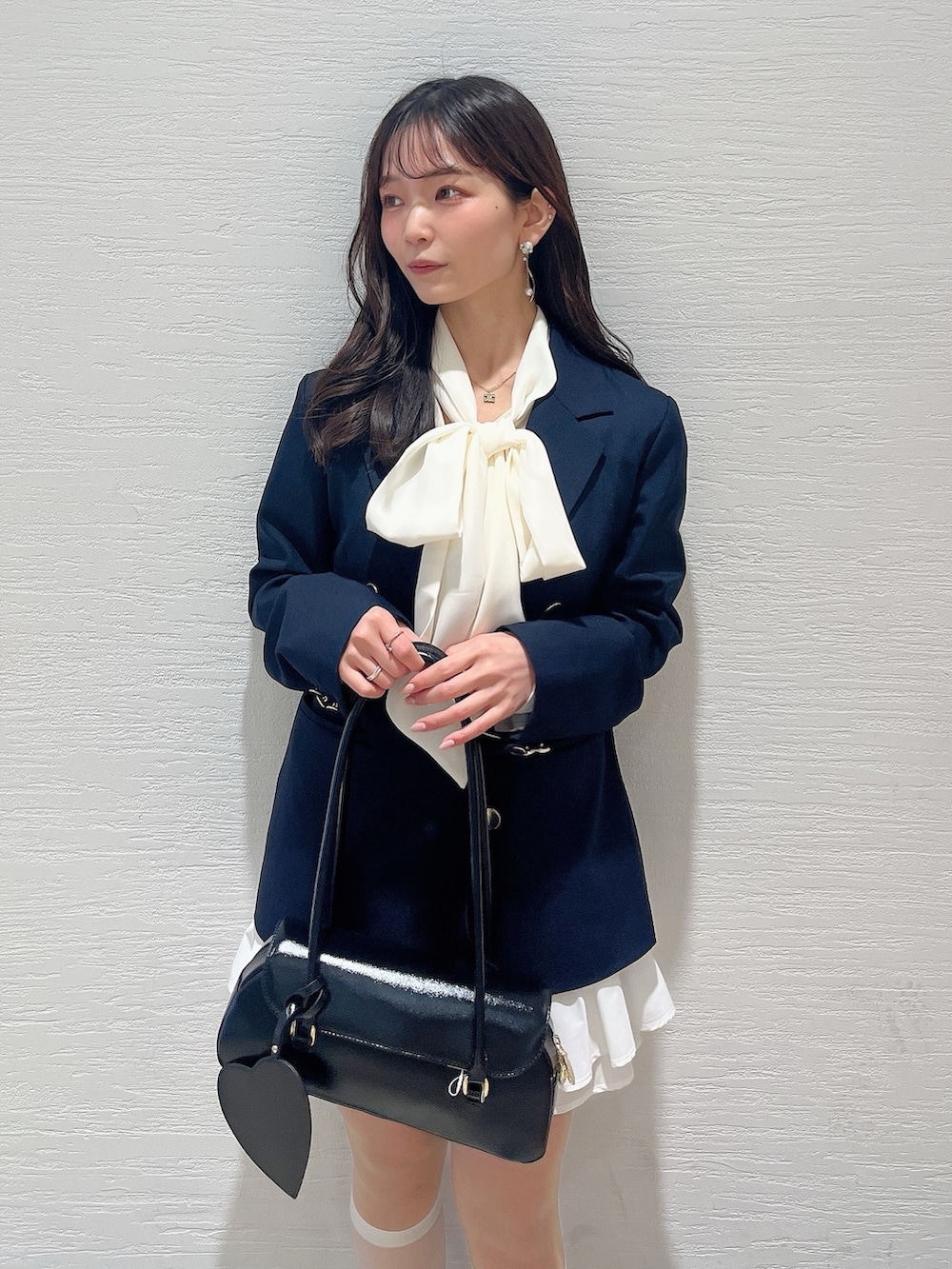 ホワイト系のシャツ/ブラウス、ホワイト系のスカート、ブラック系のバレエシューズを着用したレディースの春コーディネートの6枚目の写真