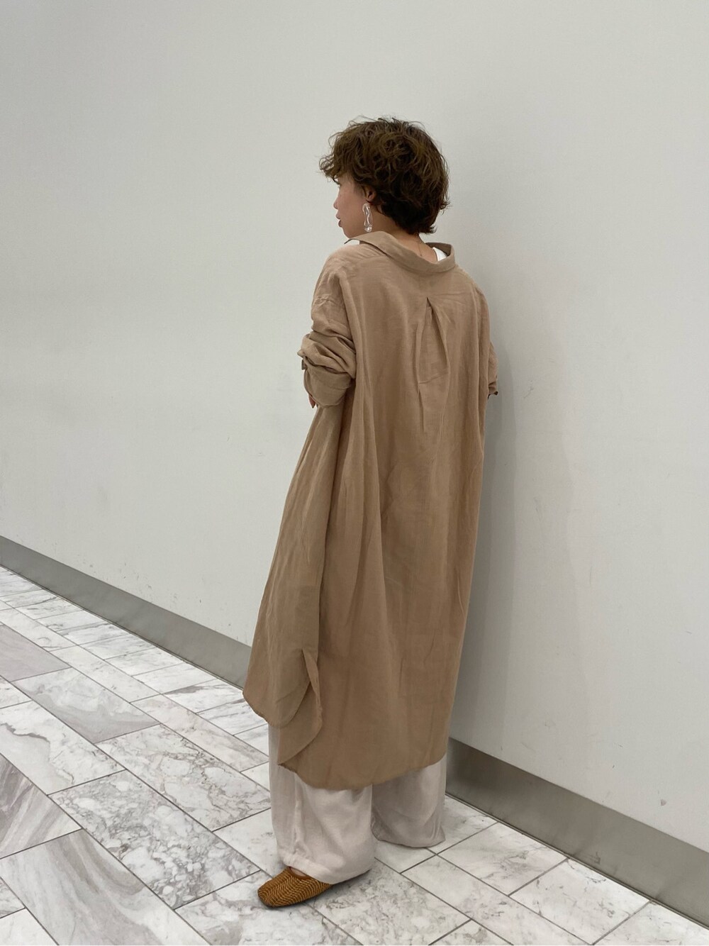 ベージュ系のワンピース、ベージュ系のその他パンツ、ホワイト系のタンクトップを着用したレディースの春コーディネートの3枚目の写真