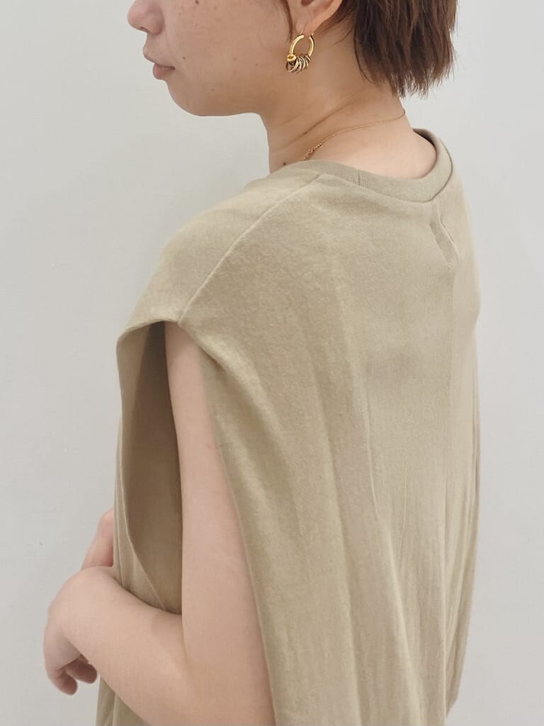 ベージュ系のワンピース、ホワイト系のサンダル、ブルー系のデニムパンツを着用したレディースの夏コーディネートの3枚目の写真