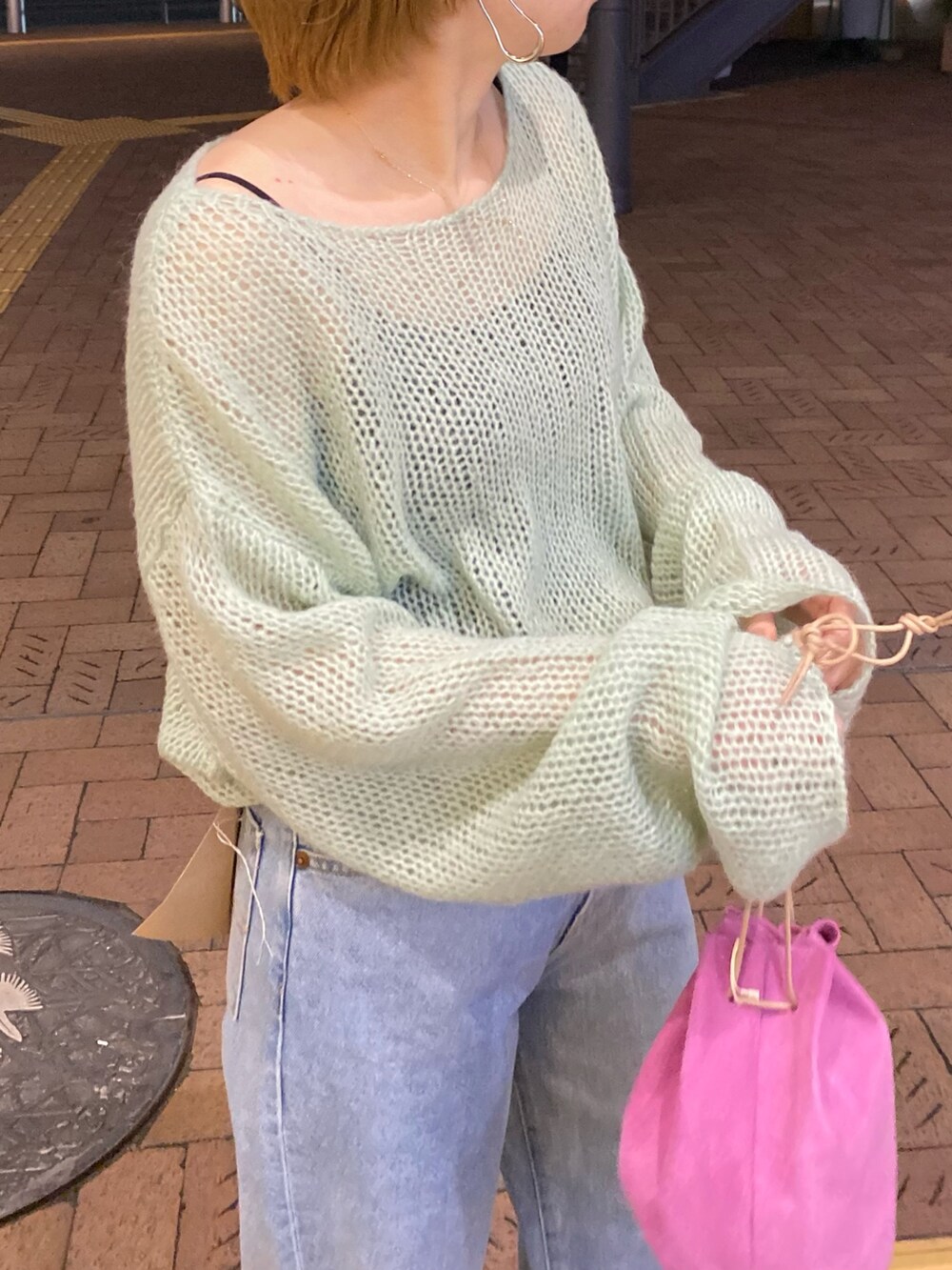 グリーン系のニット/セーター、ブルー系のデニムパンツ、ピンク系のハンドバッグを着用したレディースの冬コーディネートの4枚目の写真