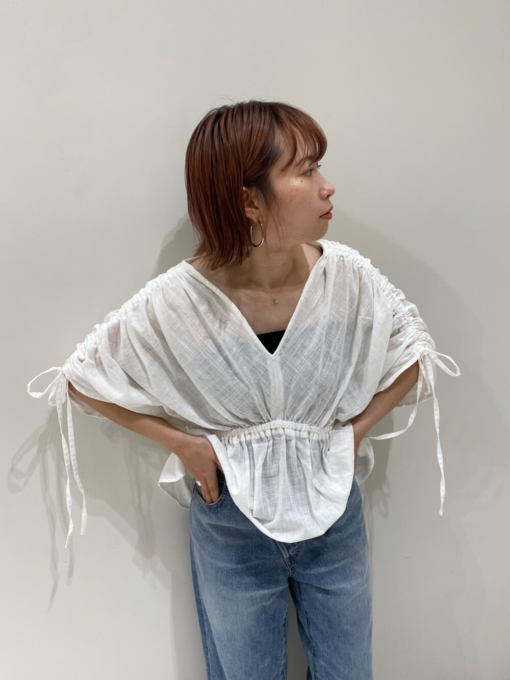 ホワイト系のシャツ/ブラウス、オレンジ系のトートバッグ、ブルー系のデニムパンツを着用したレディースの夏コーディネートの2枚目の写真