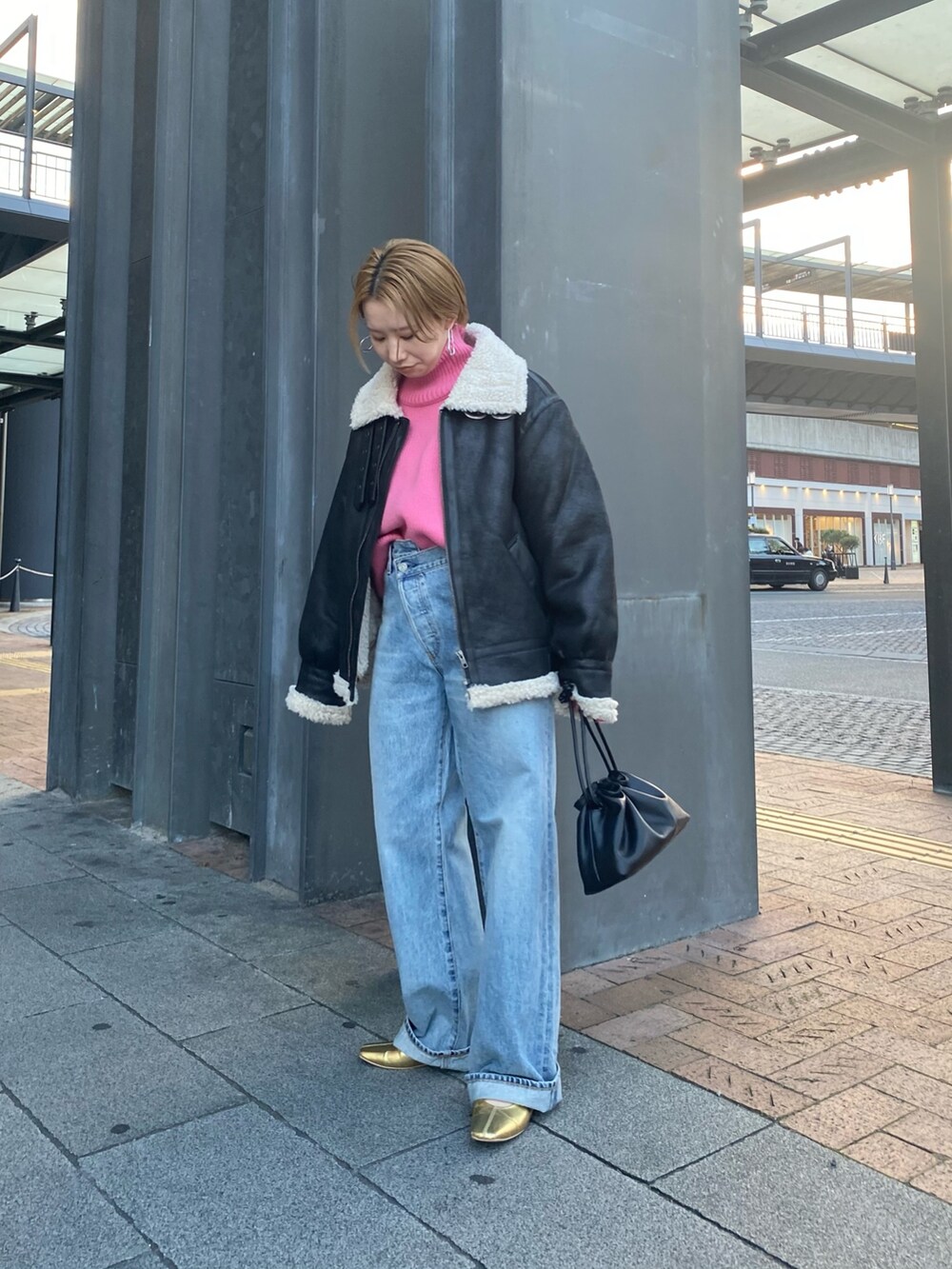 ピンク系のニット/セーター、ブルー系のデニムパンツ、ブラック系のクラッチバッグを着用したレディースの秋コーディネートの4枚目の写真