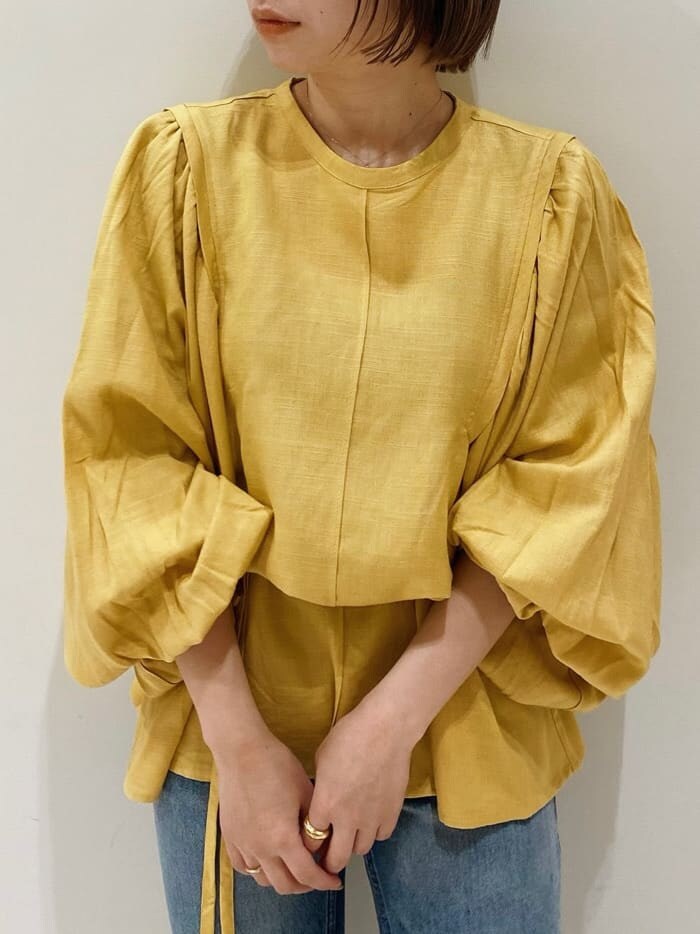 ブラウン系のパンプス、イエロー系のシャツ/ブラウス、ブルー系のデニムパンツを着用したレディースの春コーディネートの3枚目の写真