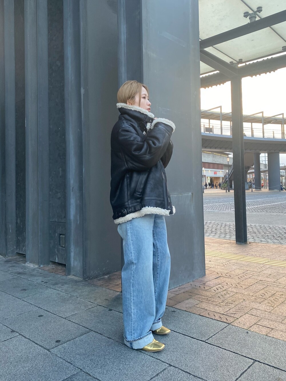 ピンク系のニット/セーター、ブルー系のデニムパンツ、ブラック系のクラッチバッグを着用したレディースの秋コーディネートの5枚目の写真