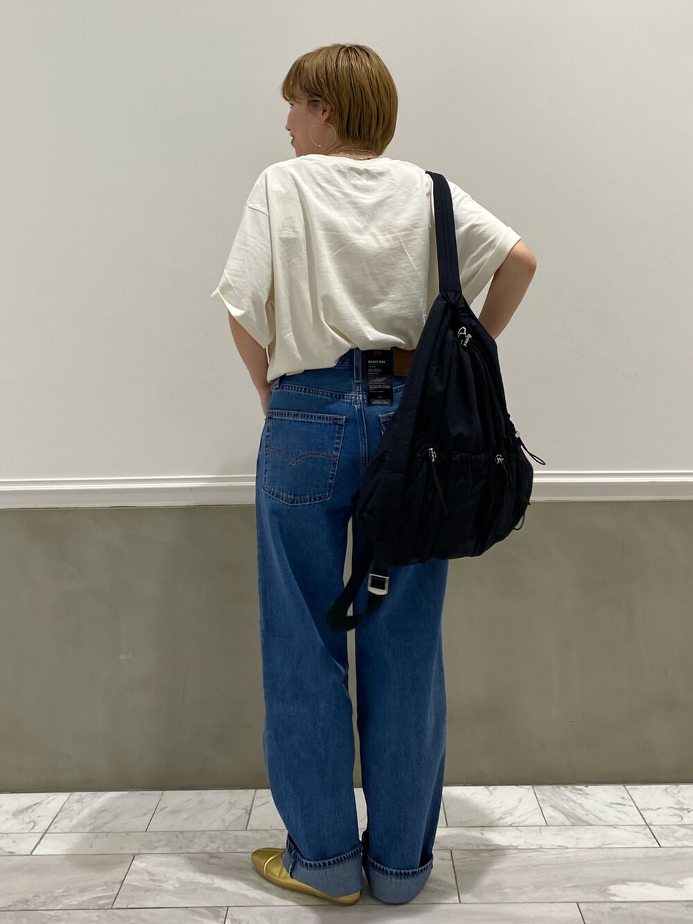 ホワイト系のTシャツ/カットソー、ブラック系のバックパック/リュックを着用したレディースの春コーディネートの2枚目の写真