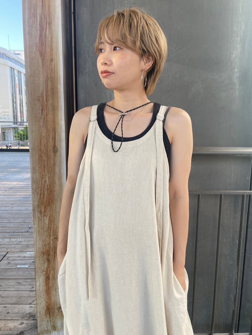 グレー系のTシャツ/カットソー、ブラック系のサンダル、ホワイト系のワンピースを着用したレディースの夏コーディネートの4枚目の写真