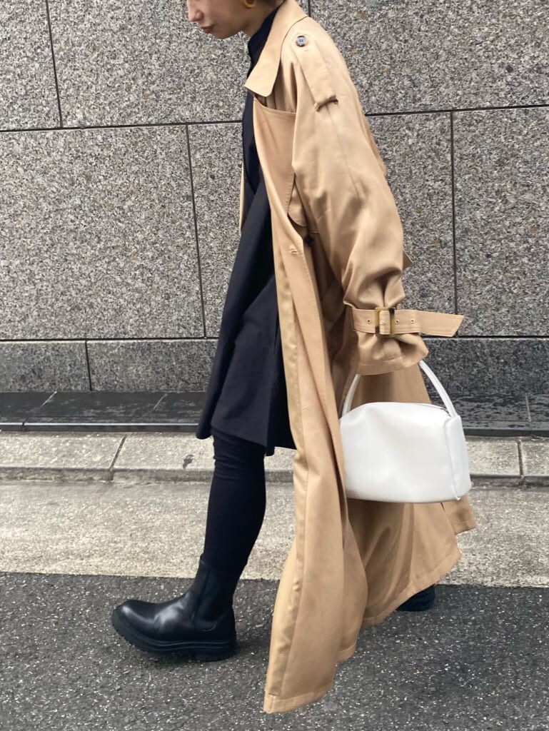ベージュ系のトレンチコート、ブラック系のシャツ/ブラウス、ホワイト系のハンドバッグを着用したレディースの冬コーディネートの8枚目の写真
