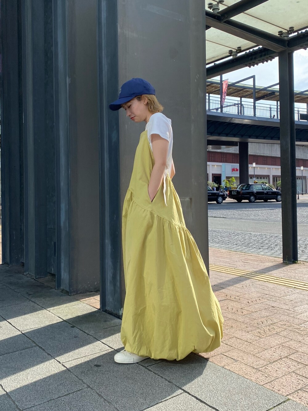 グリーン系のワンピース、ホワイト系のTシャツ/カットソー、ホワイト系のスニーカーを着用したレディースの春コーディネートの2枚目の写真