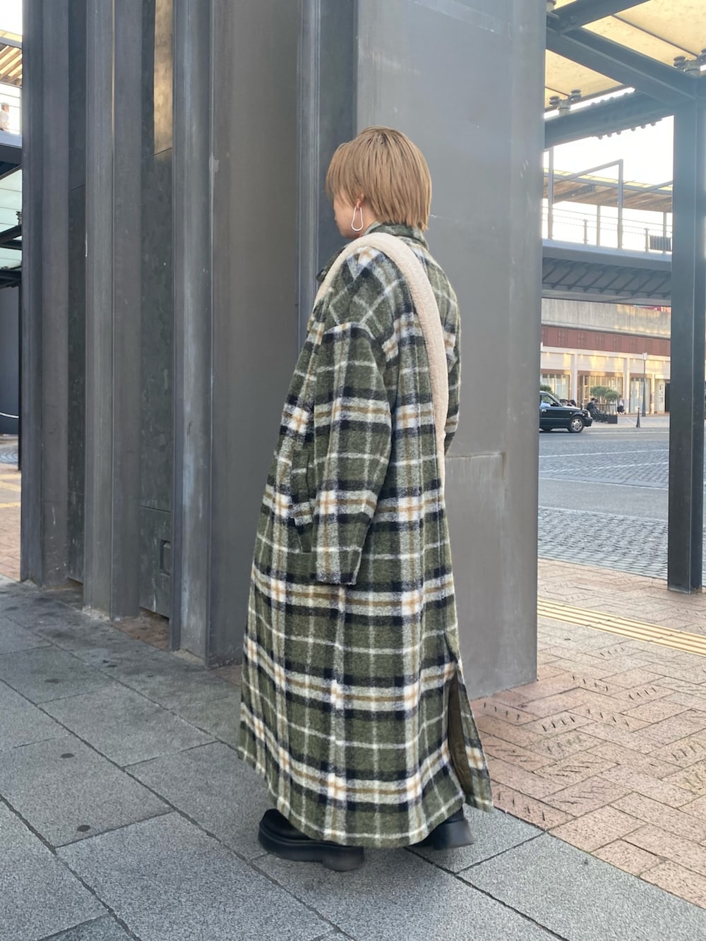 オレンジ系のニット/セーター、ホワイト系のショルダーバッグ、ブルー系のデニムパンツを着用したレディースの秋コーディネートの3枚目の写真