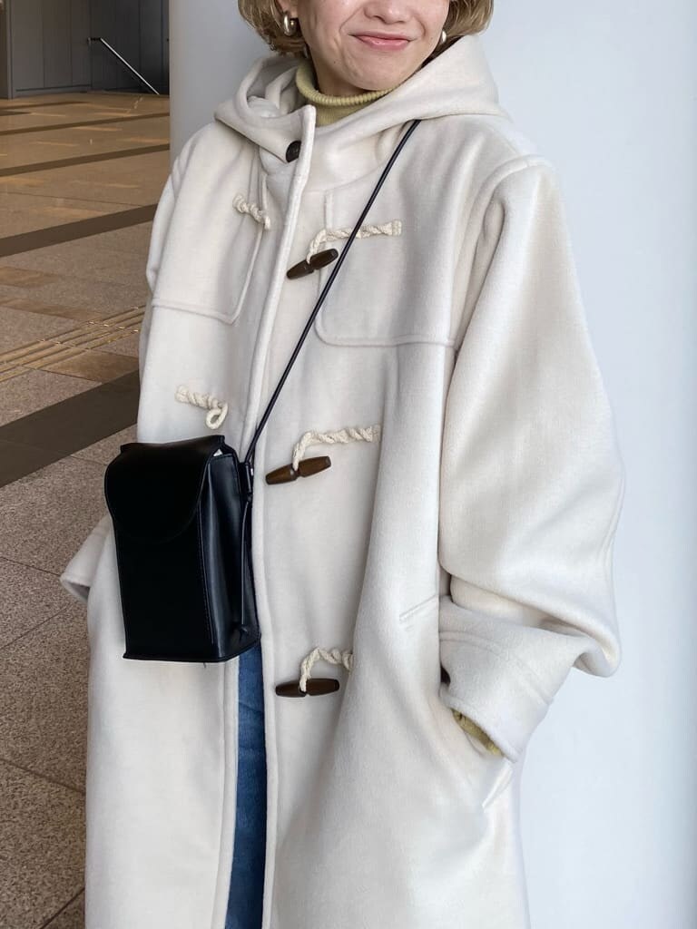 ブルー系のデニムパンツ、ブルー系のスニーカー、ホワイト系のダッフルコートを着用したレディースの冬コーディネートの3枚目の写真