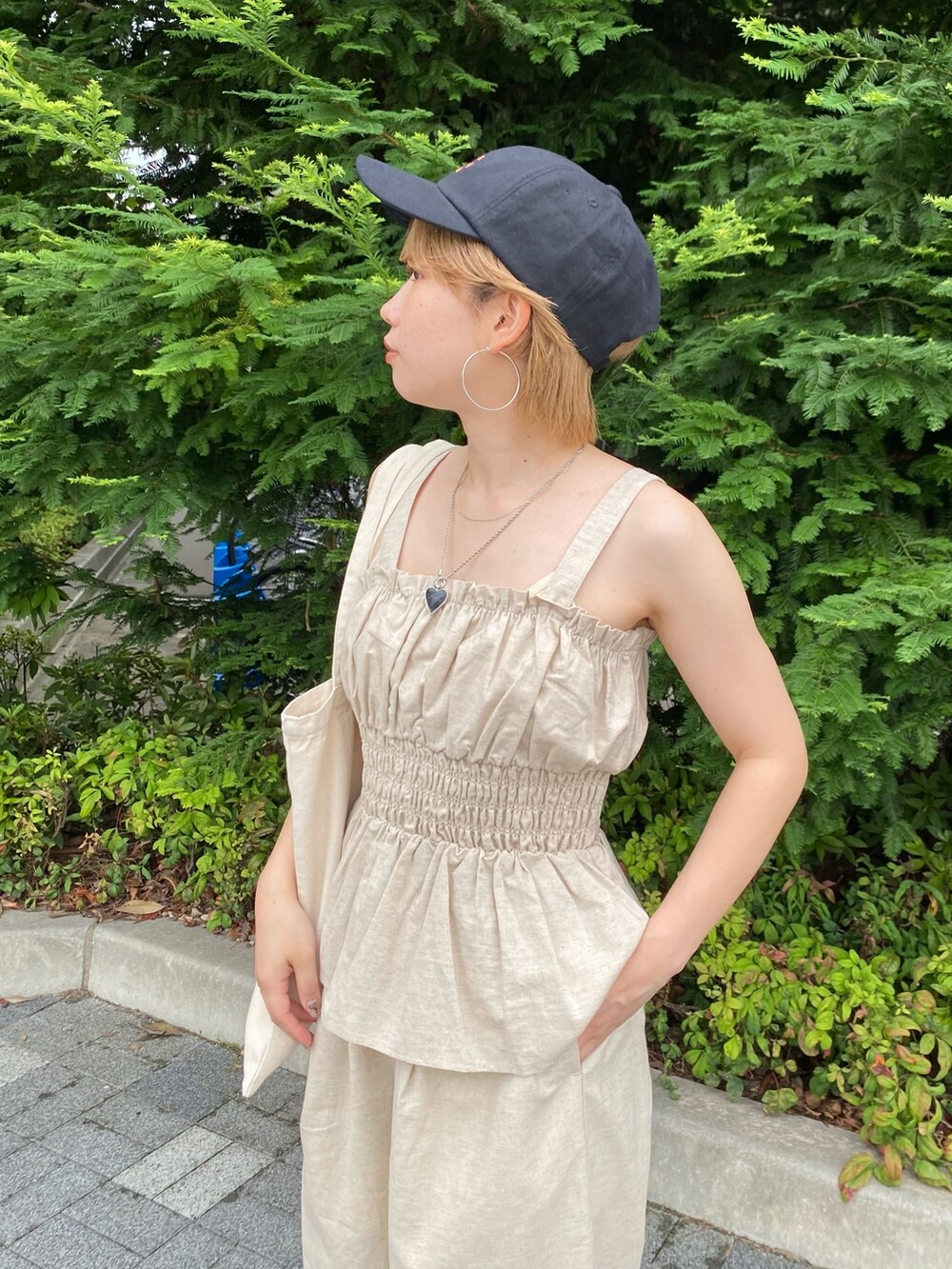 ホワイト系のキャミソール、ホワイト系のその他パンツ、ブラック系のサンダルを着用したレディースの夏コーディネートの4枚目の写真