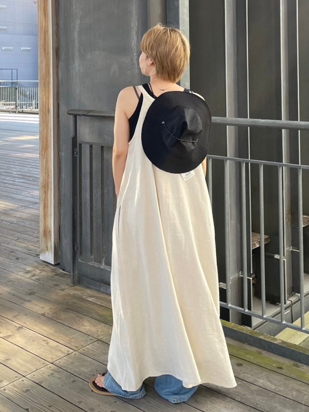 グレー系のTシャツ/カットソー、ブラック系のサンダル、ホワイト系のワンピースを着用したレディースの夏コーディネートの6枚目の写真