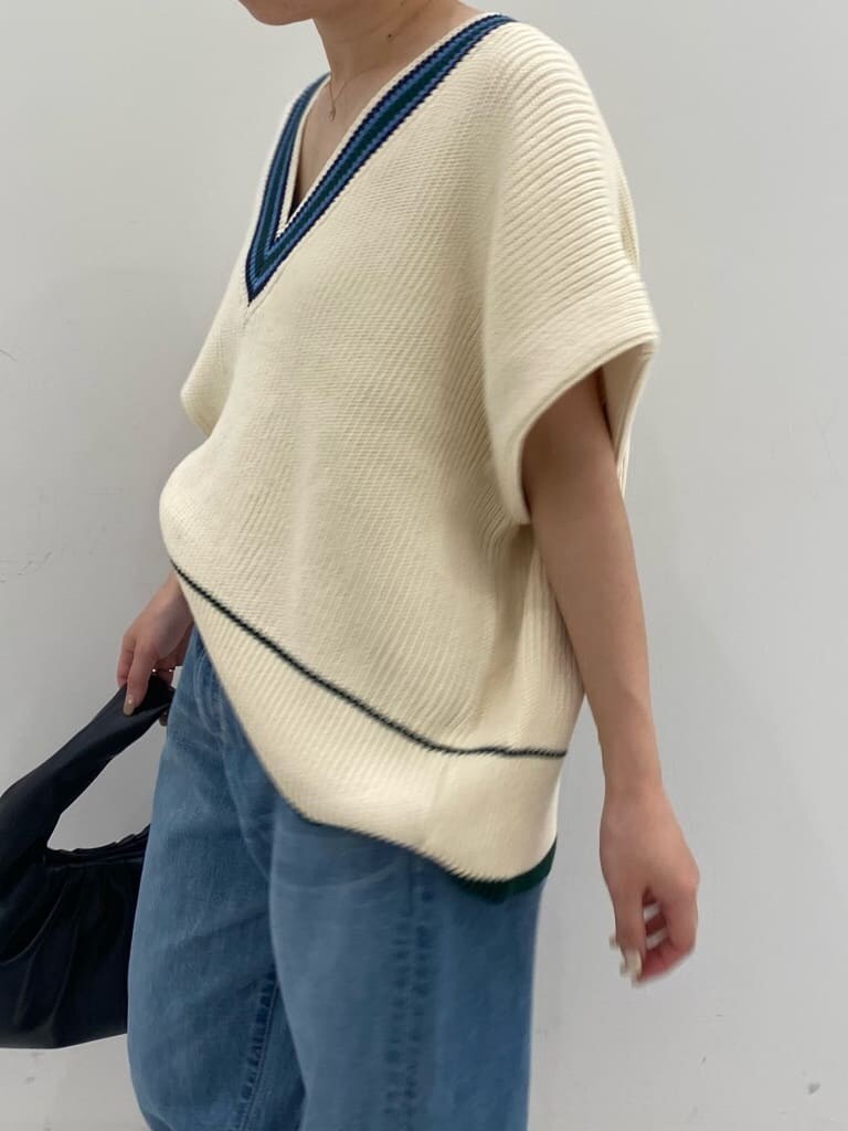 ベージュ系のトレンチコート、ゴールド系のパンプス、ブルー系のデニムパンツを着用したレディースの秋コーディネートの5枚目の写真
