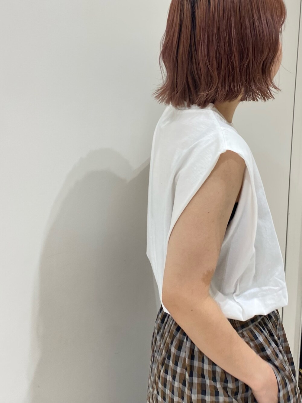 ブラウン系のスカート、ホワイト系のタンクトップを着用したレディースの夏コーディネートの3枚目の写真