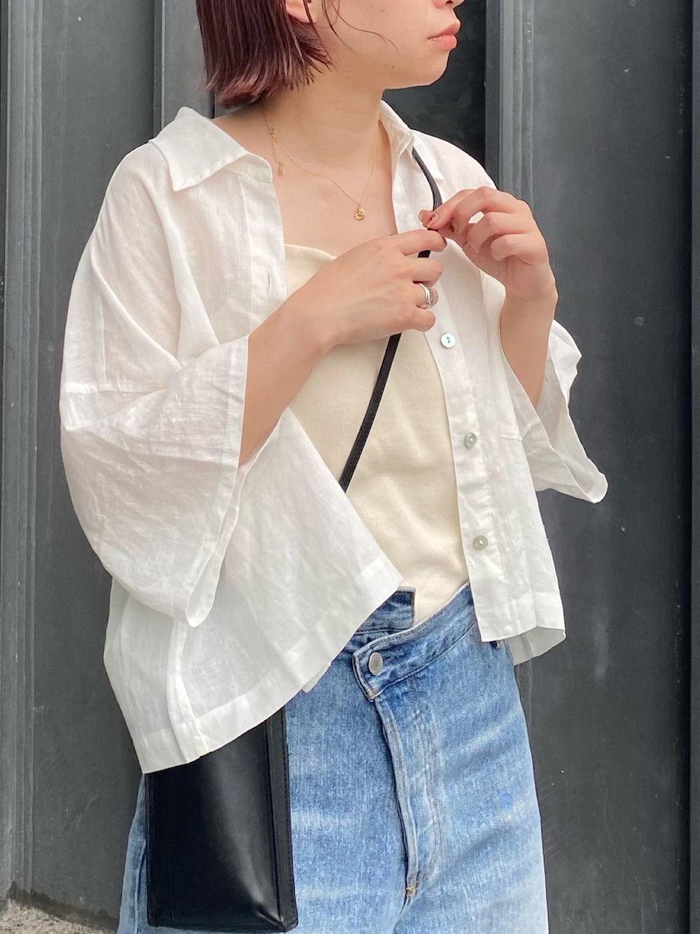 ホワイト系のシャツ/ブラウス、ホワイト系のキャミソール、ブルー系のデニムパンツを着用したレディースの夏コーディネートの3枚目の写真