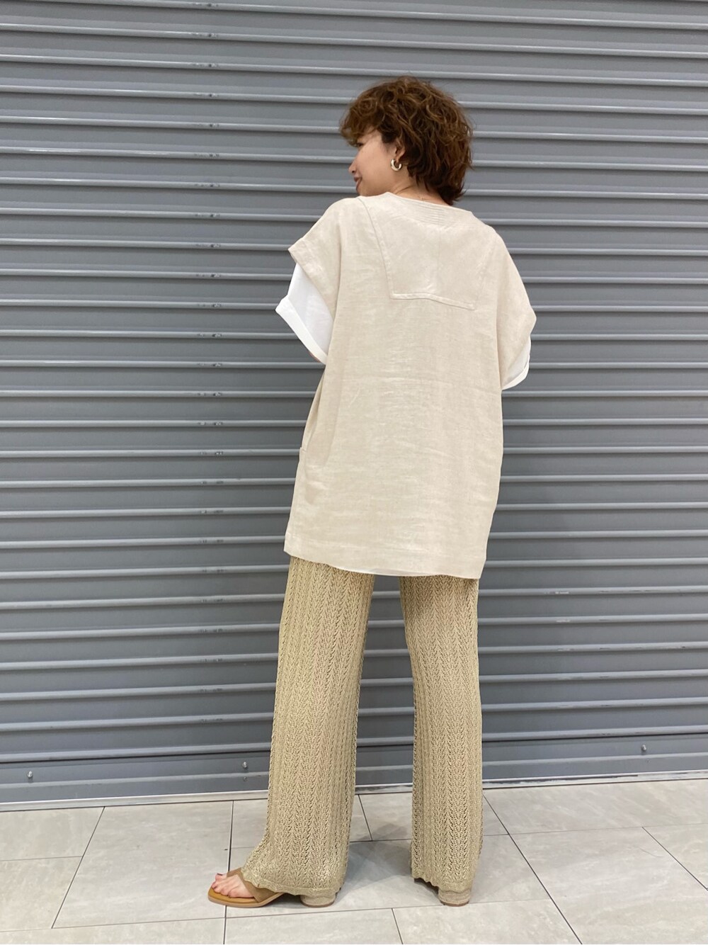 ブラウン系のサンダル、ホワイト系のシャツ/ブラウス、ゴールド系のその他パンツを着用したレディースの春コーディネートの3枚目の写真