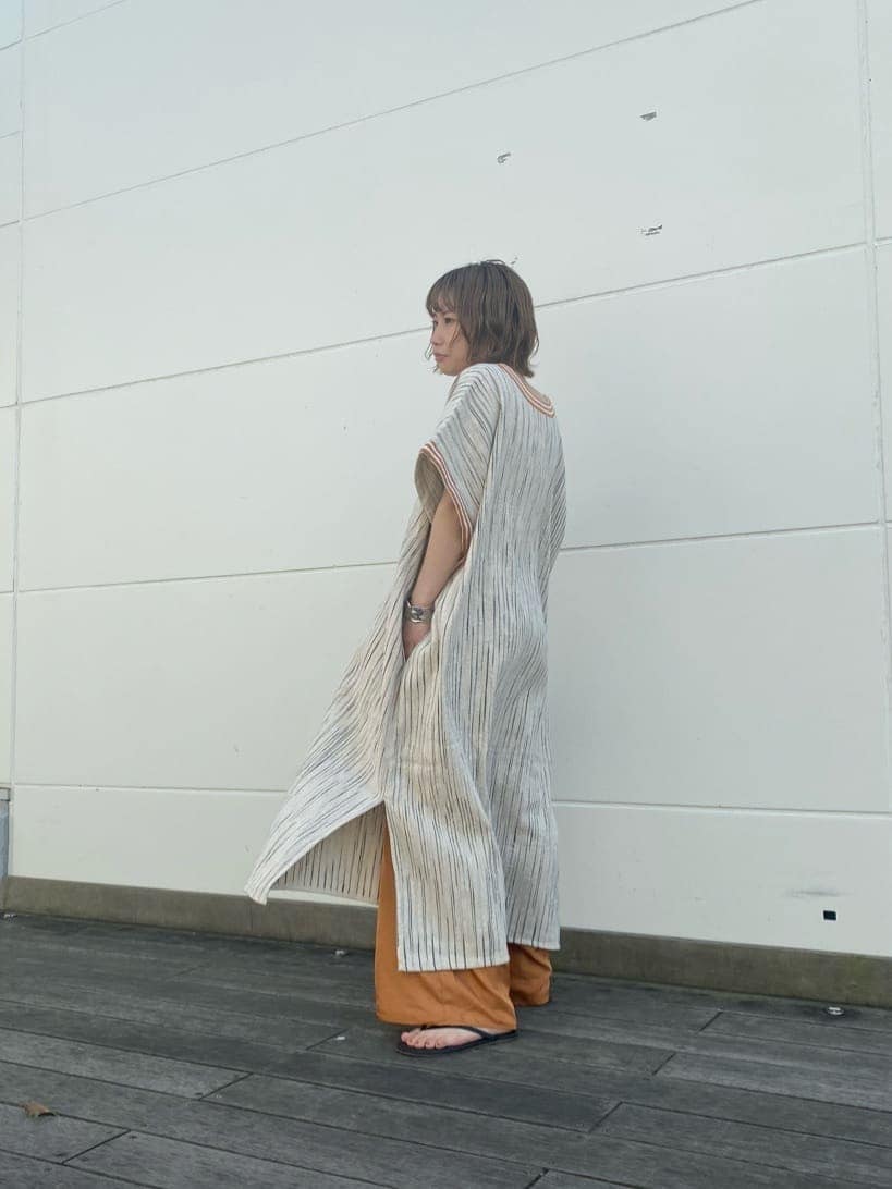 オレンジ系のその他パンツ、オレンジ系のワンピース、ブラック系のハンドバッグを着用したレディースの春コーディネートの5枚目の写真