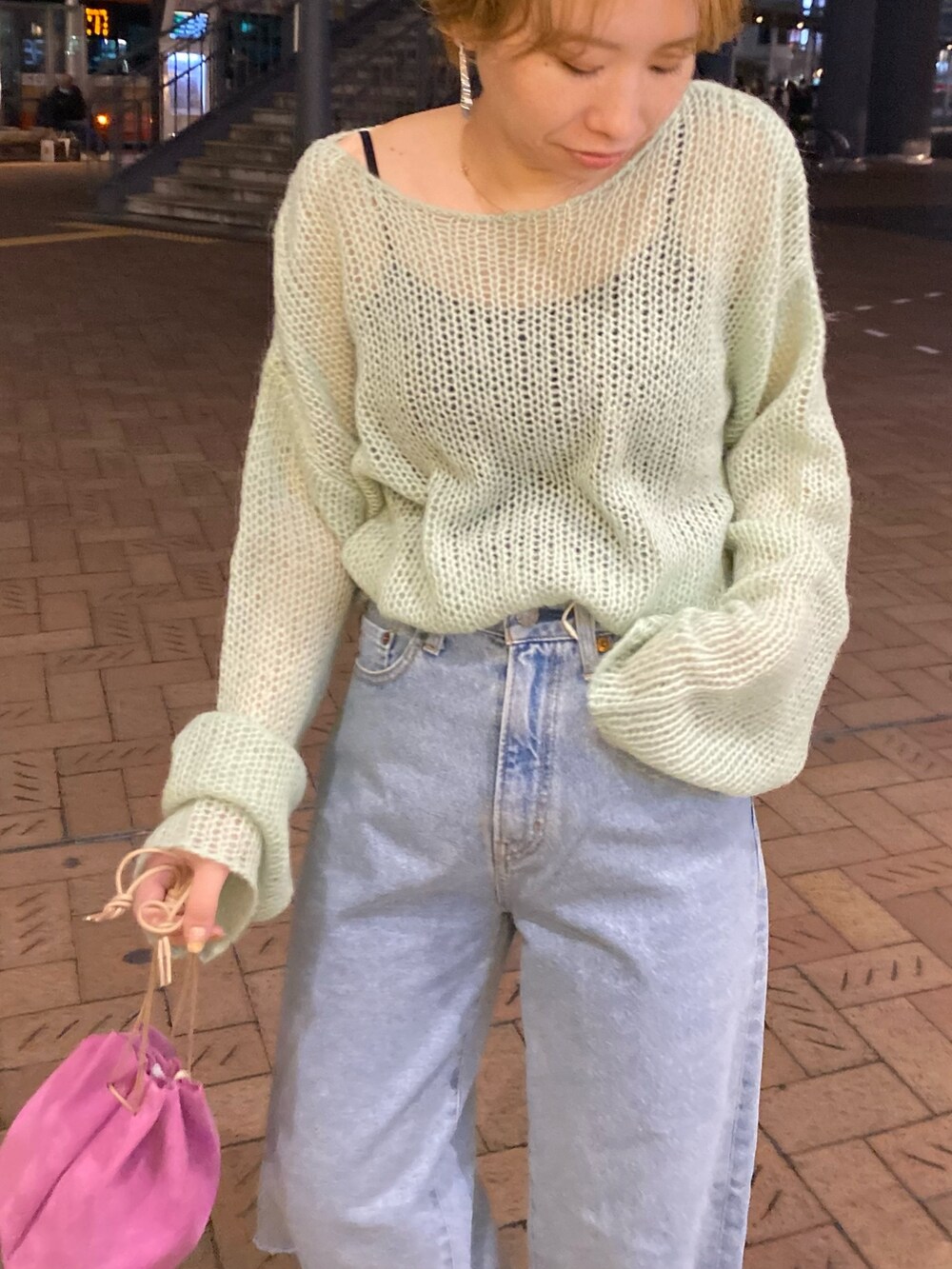 グリーン系のニット/セーター、ブルー系のデニムパンツ、ピンク系のハンドバッグを着用したレディースの冬コーディネートの3枚目の写真