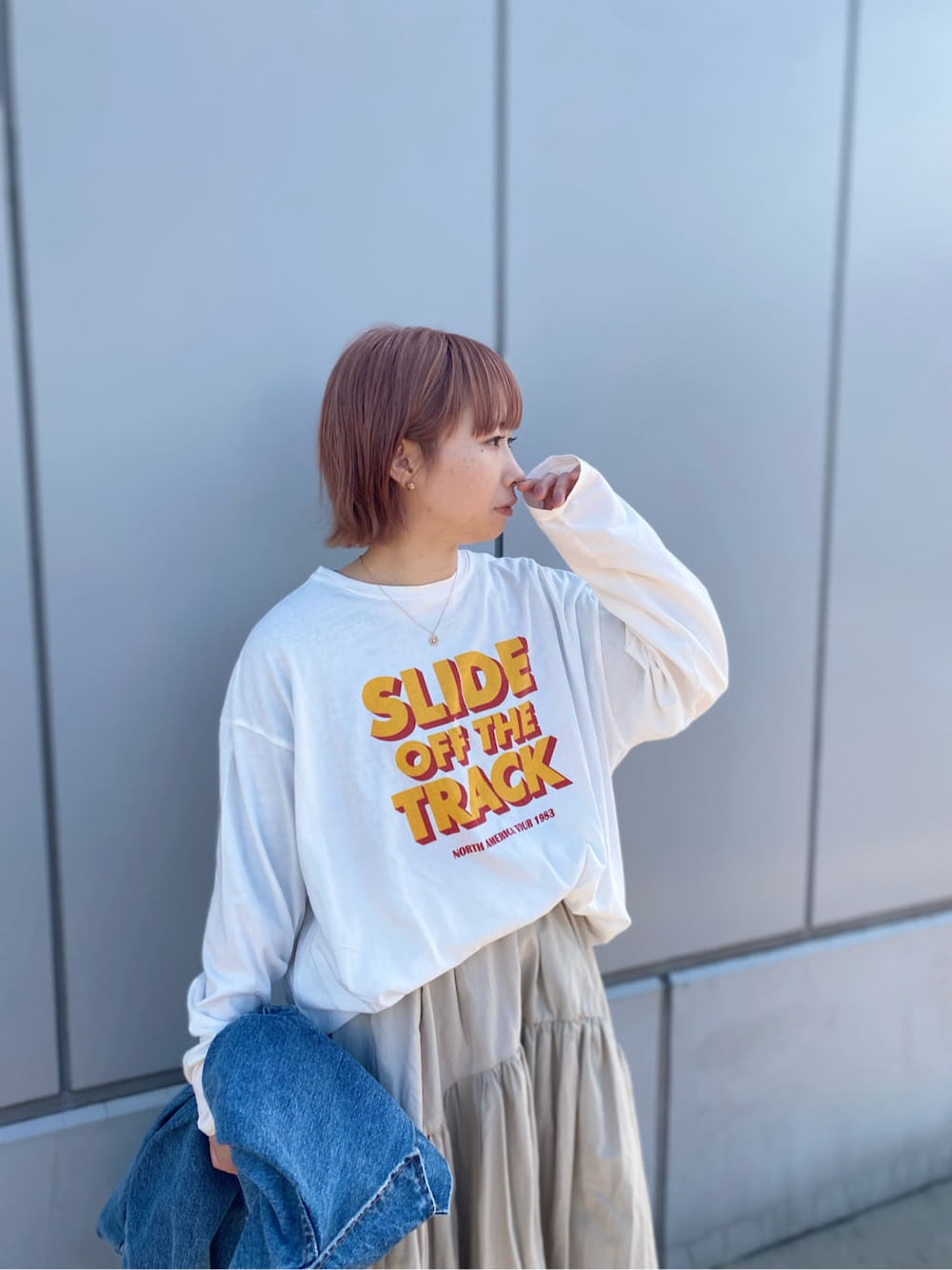ホワイト系のスカート、ホワイト系のTシャツ/カットソー、ブルー系のデニムジャケットを着用したレディースの冬コーディネートの2枚目の写真