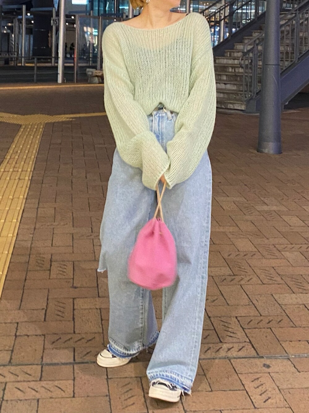 グリーン系のニット/セーター、ブルー系のデニムパンツ、ピンク系のハンドバッグを着用したレディースの冬コーディネートの2枚目の写真