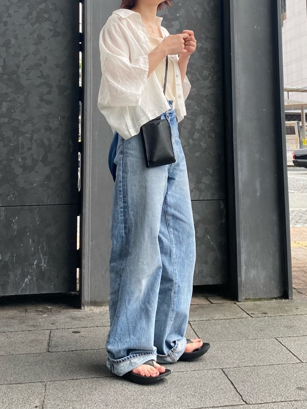 ホワイト系のシャツ/ブラウス、ホワイト系のキャミソール、ブルー系のデニムパンツを着用したレディースの夏コーディネートの4枚目の写真