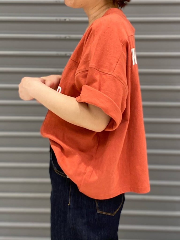 ブルー系のデニムパンツ、オレンジ系のTシャツ/カットソーを着用したレディースの春コーディネートの2枚目の写真
