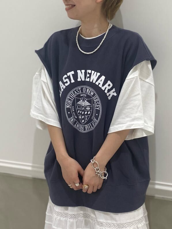 ホワイト系のスカート、ブラウン系のブーツ、ブラウン系のトレンチコートを着用したレディースの夏コーディネートの2枚目の写真