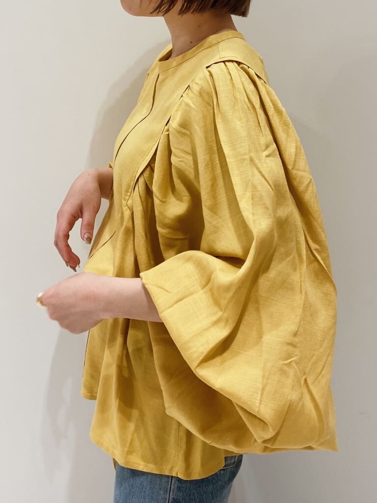 ブラウン系のパンプス、イエロー系のシャツ/ブラウス、ブルー系のデニムパンツを着用したレディースの春コーディネートの2枚目の写真