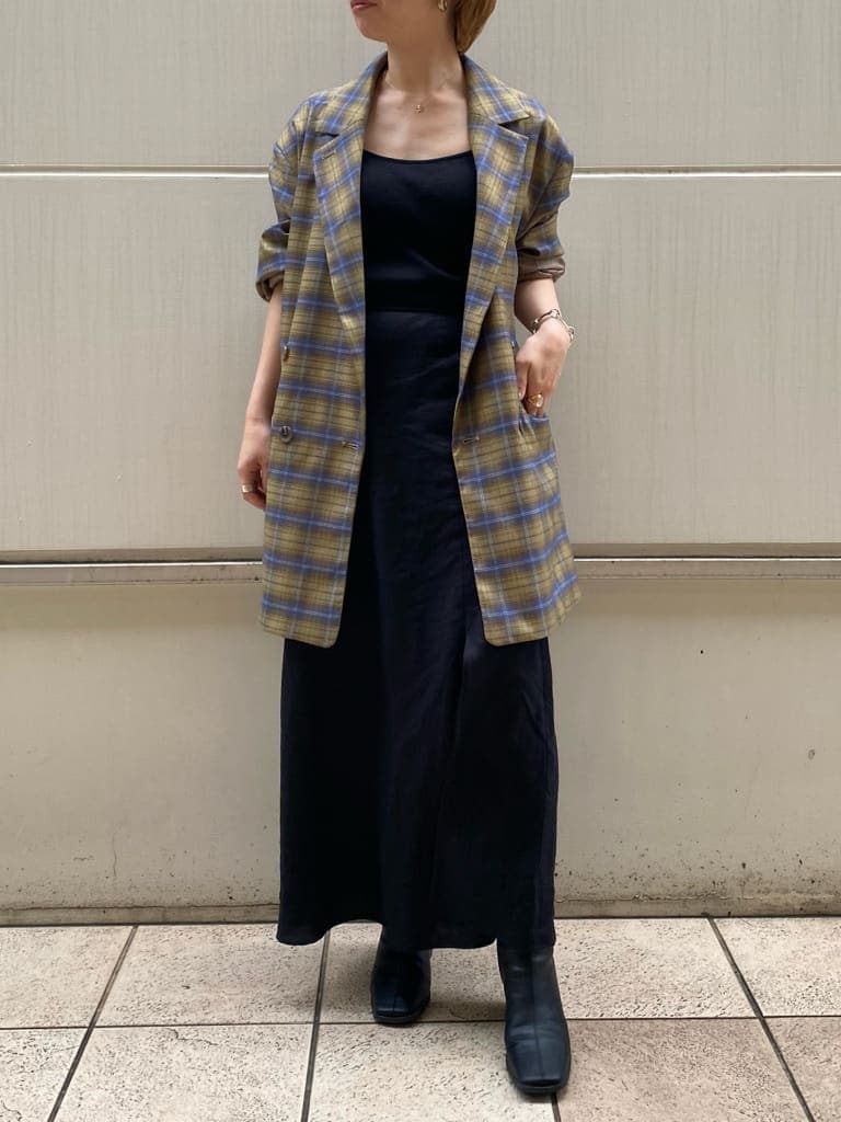 ブラック系のスカート、イエロー系のテーラードジャケット、ブラック系のブーツを着用したレディースの夏コーディネートの2枚目の写真