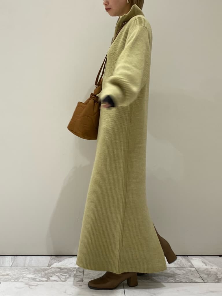 ブラック系のTシャツ/カットソー、ブラウン系のチェスターコート、グリーン系のワンピースを着用したレディースの冬コーディネートの2枚目の写真