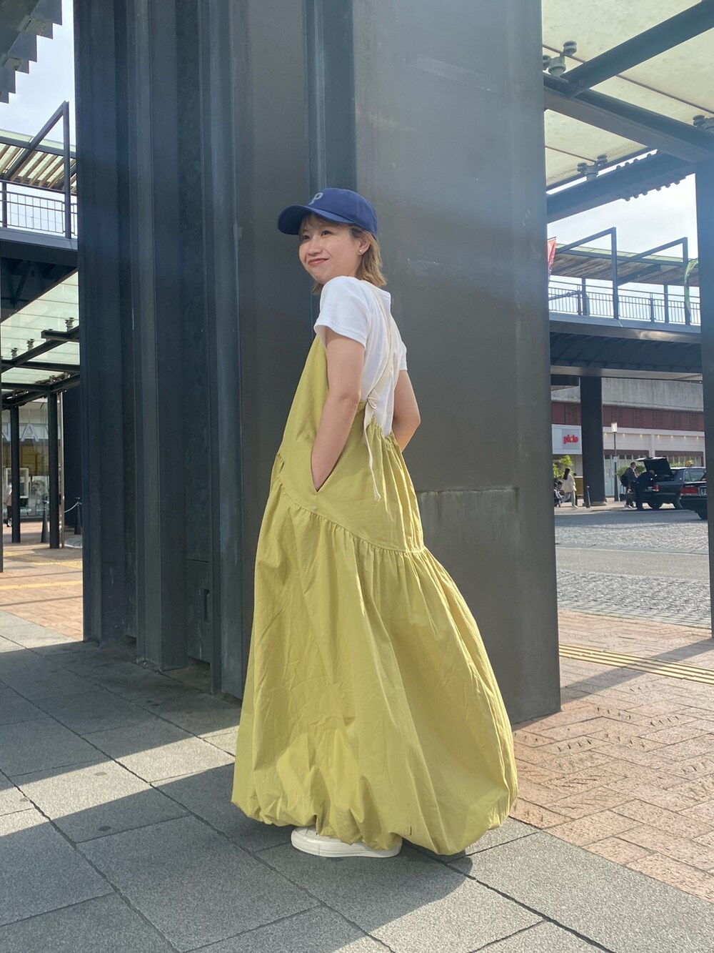 グリーン系のワンピース、ホワイト系のTシャツ/カットソー、ホワイト系のスニーカーを着用したレディースの春コーディネートの4枚目の写真