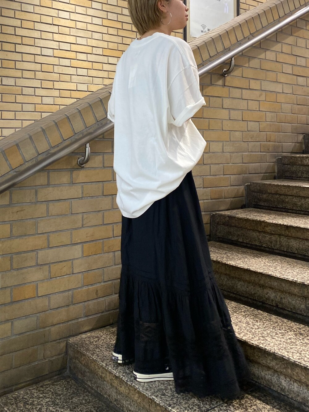 ブラック系のスカート、ホワイト系のTシャツ/カットソーを着用したレディースの夏コーディネートの2枚目の写真