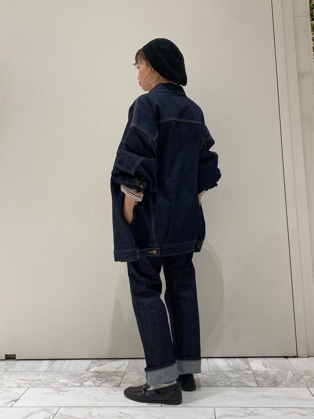 ブルー系のデニムジャケット、ブルー系のデニムパンツ、ブラウン系のシャツ/ブラウスを着用したレディースの秋コーディネートの2枚目の写真