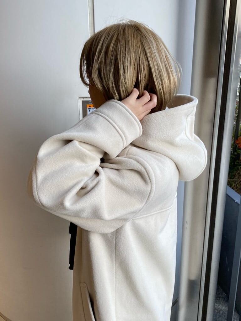 ブルー系のデニムパンツ、ブルー系のスニーカー、ホワイト系のダッフルコートを着用したレディースの冬コーディネートの4枚目の写真