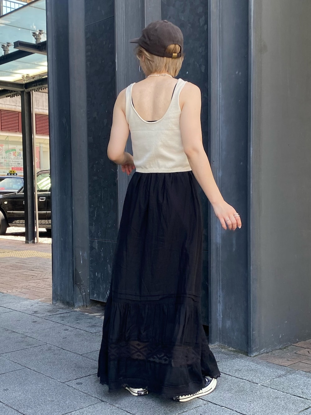 ホワイト系のベスト、ブラック系のスカートを着用したレディースの夏コーディネートの3枚目の写真
