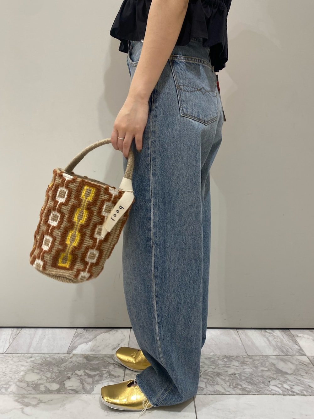 ブラック系のワンピース、ホワイト系のTシャツ/カットソー、ゴールド系のパンプスを着用したレディースの春コーディネートの7枚目の写真