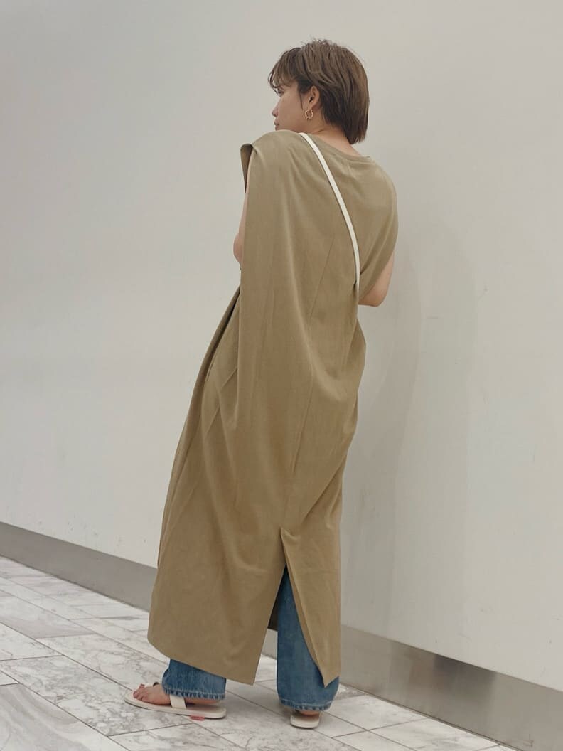 ベージュ系のワンピース、ホワイト系のサンダル、ブルー系のデニムパンツを着用したレディースの夏コーディネートの4枚目の写真