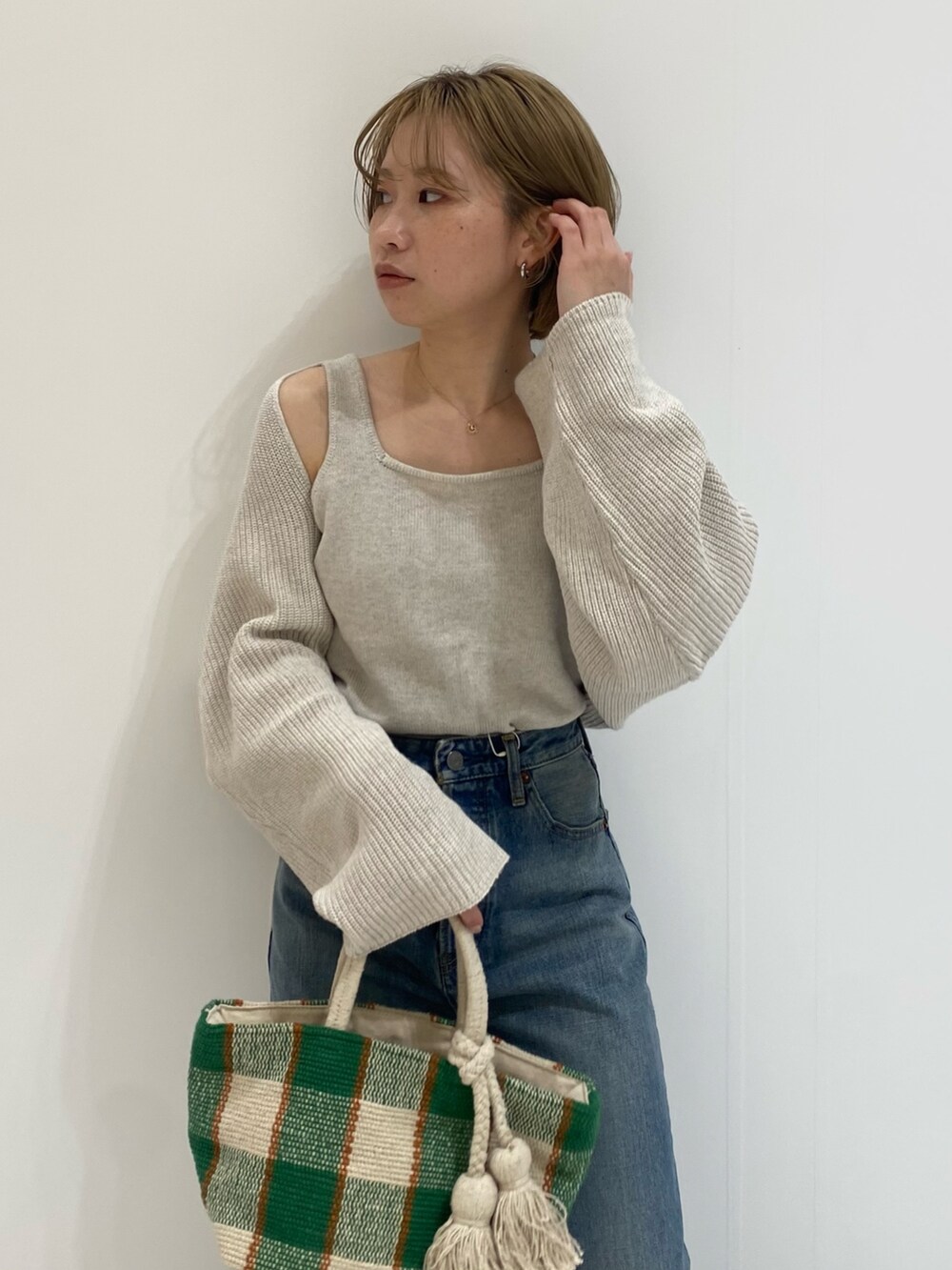 ブルー系のデニムパンツ、ホワイト系のニット/セーターを着用したレディースの春コーディネートの7枚目の写真