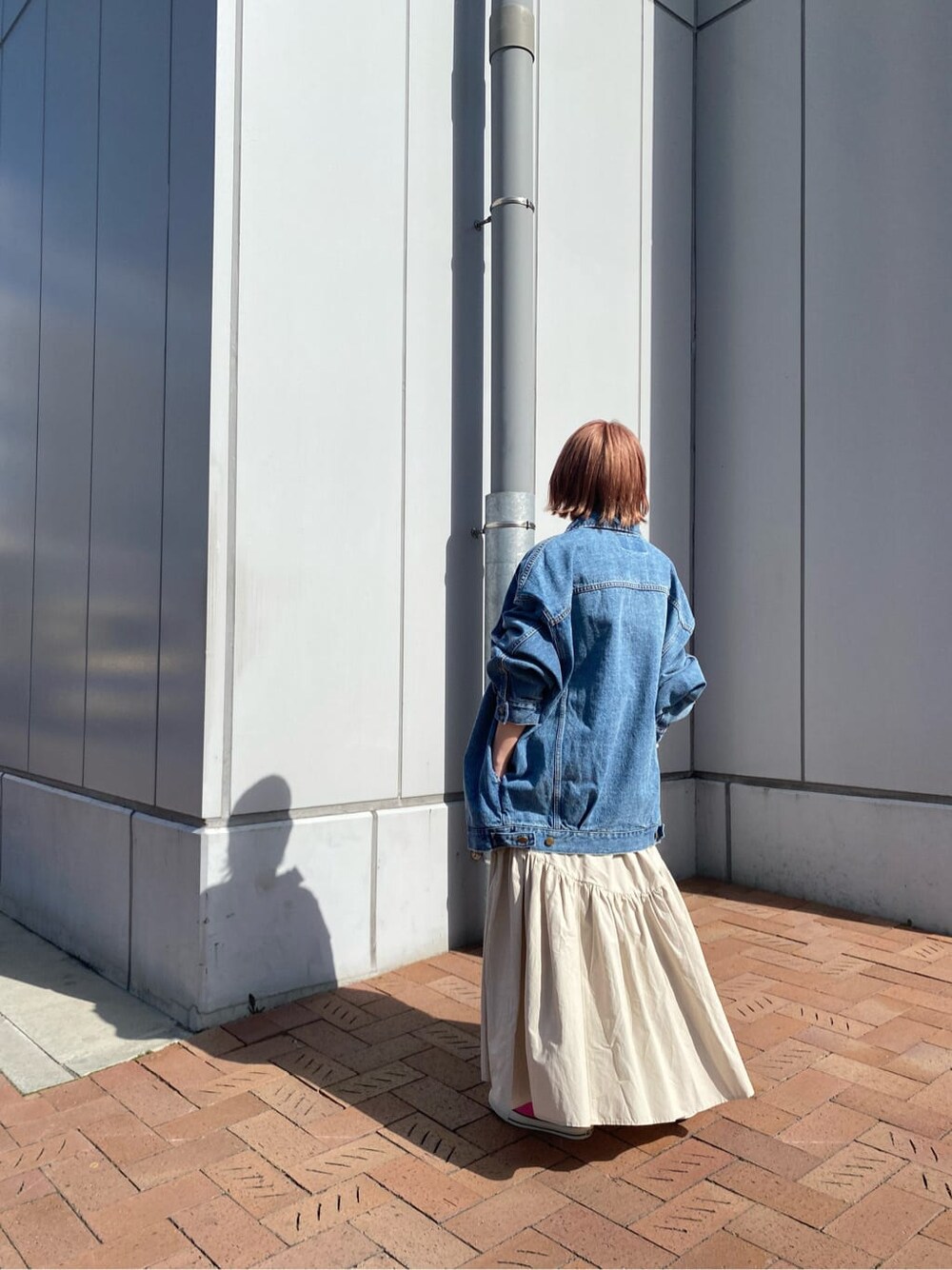 ホワイト系のスカート、ホワイト系のTシャツ/カットソー、ブルー系のデニムジャケットを着用したレディースの冬コーディネートの4枚目の写真