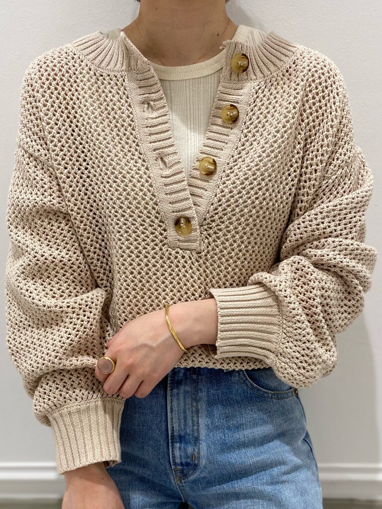 ブルー系のデニムパンツ、ホワイト系のニット/セーター、ホワイト系のタンクトップを着用したレディースの春コーディネートの4枚目の写真