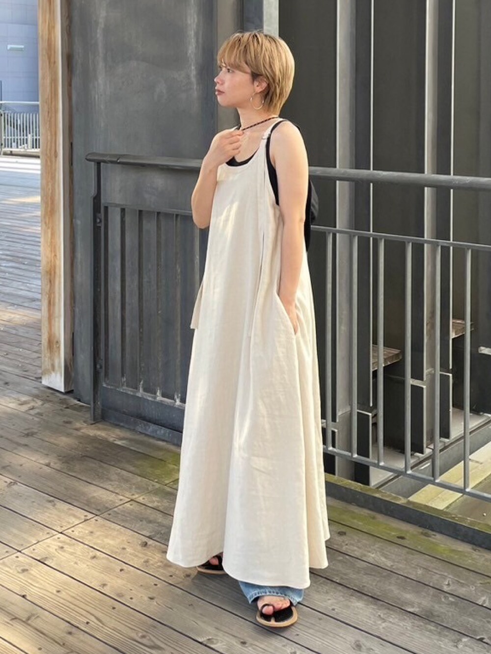 グレー系のTシャツ/カットソー、ブラック系のサンダル、ホワイト系のワンピースを着用したレディースの夏コーディネートの2枚目の写真