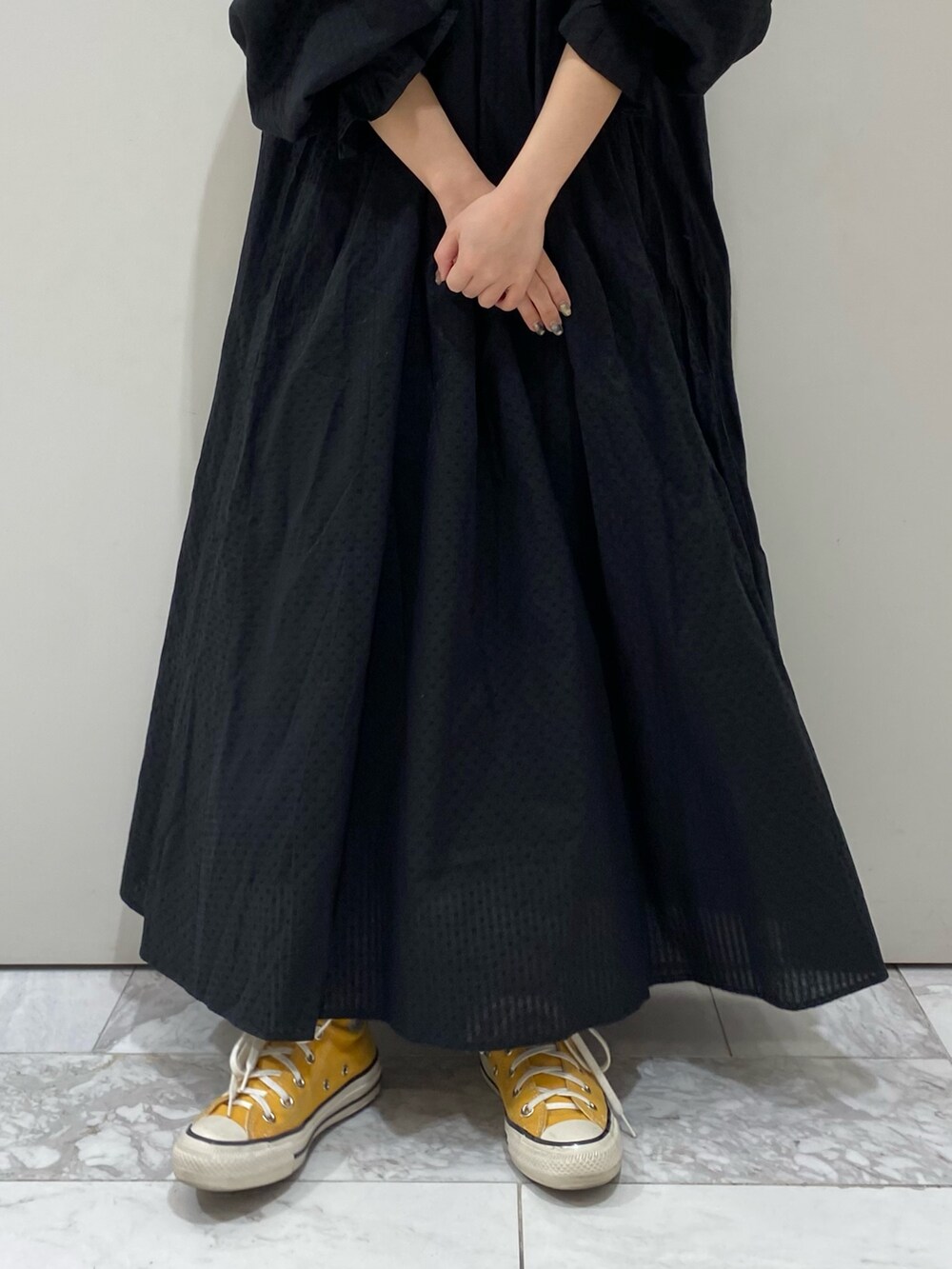 ブラック系のワンピース、オレンジ系のキャップを着用したレディースの春コーディネートの9枚目の写真