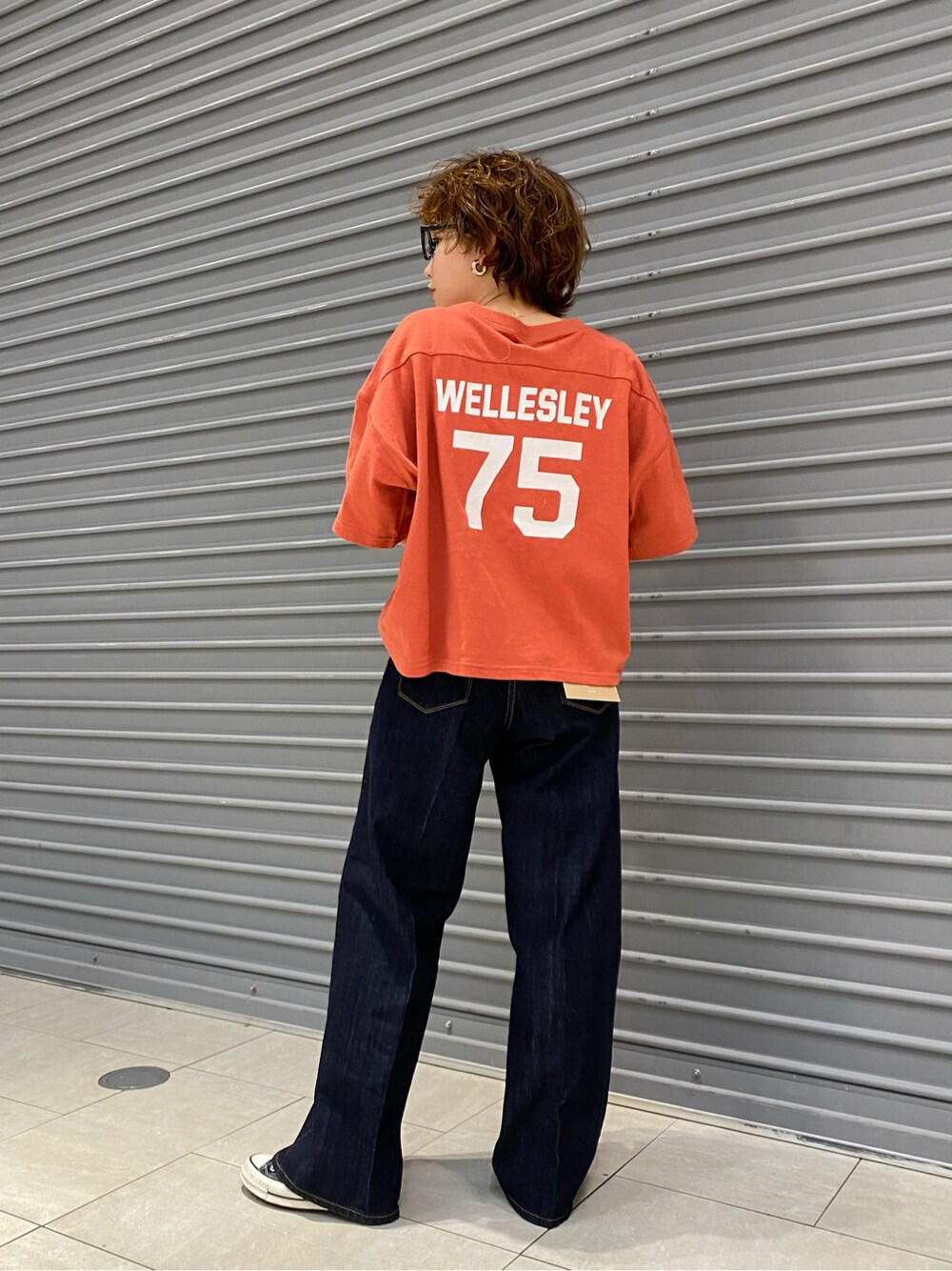 ブルー系のデニムパンツ、オレンジ系のTシャツ/カットソーを着用したレディースの春コーディネートの5枚目の写真