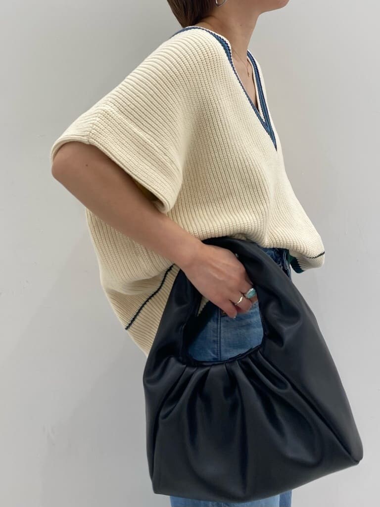 ベージュ系のトレンチコート、ゴールド系のパンプス、ブルー系のデニムパンツを着用したレディースの秋コーディネートの4枚目の写真