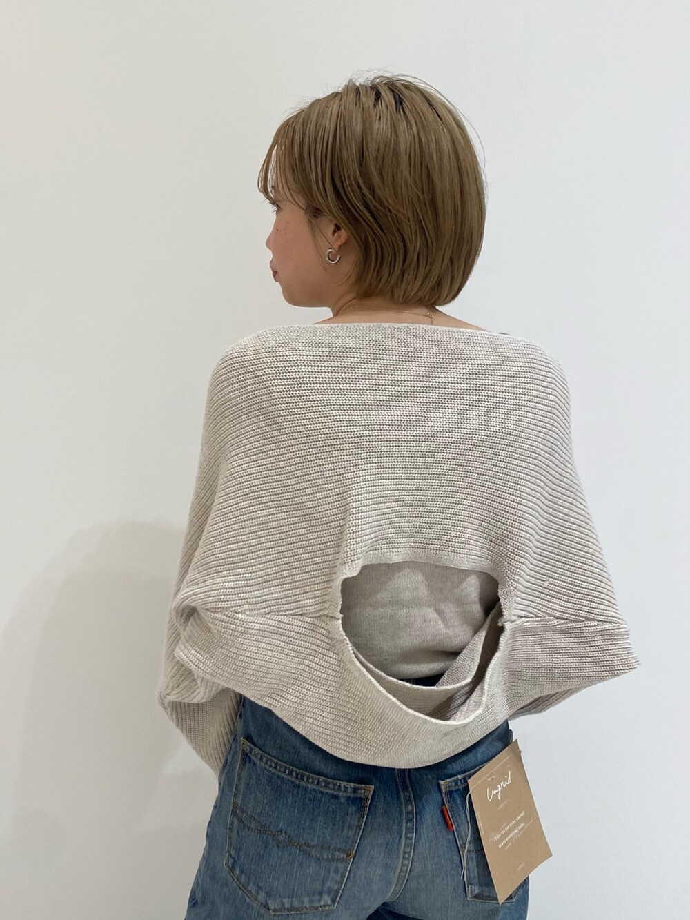 ブルー系のデニムパンツ、ホワイト系のニット/セーターを着用したレディースの春コーディネートの6枚目の写真