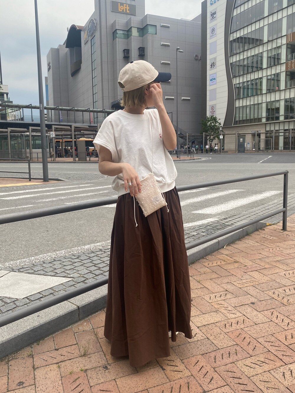 ホワイト系のTシャツ/カットソー、ブラウン系のワンピース、ホワイト系のショルダーバッグを着用したレディースの春コーディネートの3枚目の写真