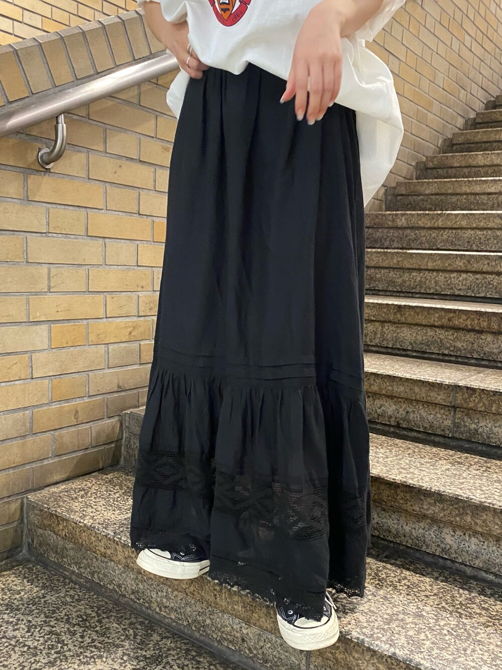 ブラック系のスカート、ホワイト系のTシャツ/カットソーを着用したレディースの夏コーディネートの6枚目の写真