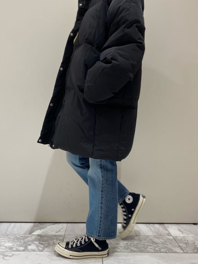 ブラック系のTシャツ/カットソー、ブルー系のデニムパンツ、ブラック系のダウンジャケット/コートを着用したレディースの秋コーディネートの4枚目の写真