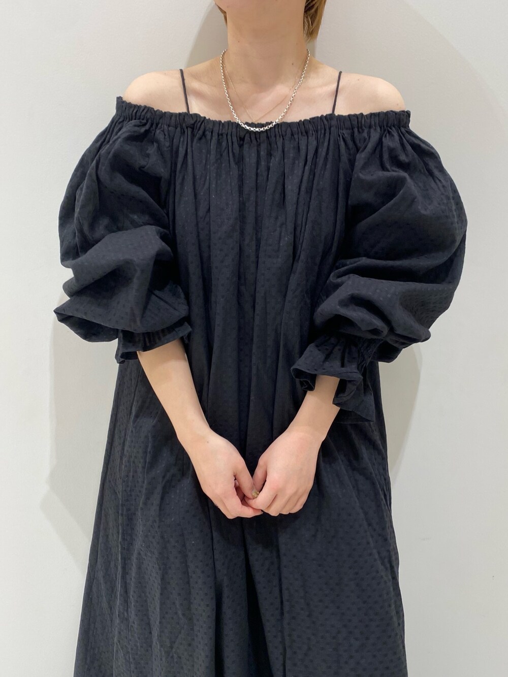 ブラック系のワンピース、オレンジ系のキャップを着用したレディースの春コーディネートの5枚目の写真